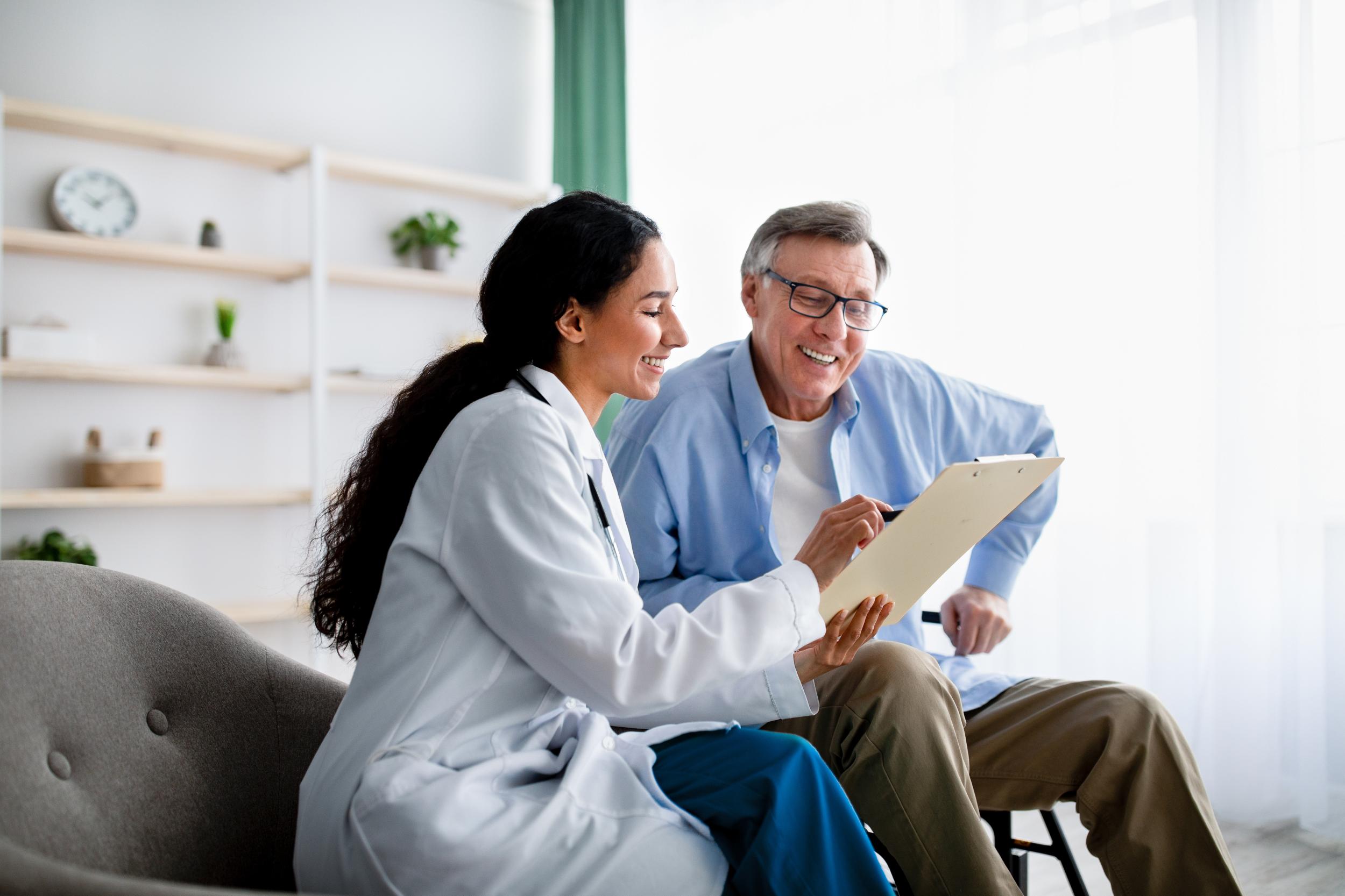 female physician reviewing a chart with an older male patient
